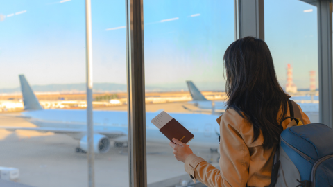 Noia a l'aeroport amb un passaport a la mà